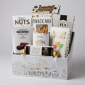 Assorted snack and treat box with various items including nuts, chocolate, and tea.