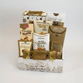 A gourmet gift basket filled with assorted chocolates, snacks, and treats, including Imperial Nuts Cashews, Siete Sal Caramel Roca, and various cookies, arranged in a white and gold cityscape-themed box.