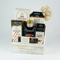 Gift basket with assorted snacks and treats in a wooden box on a white background