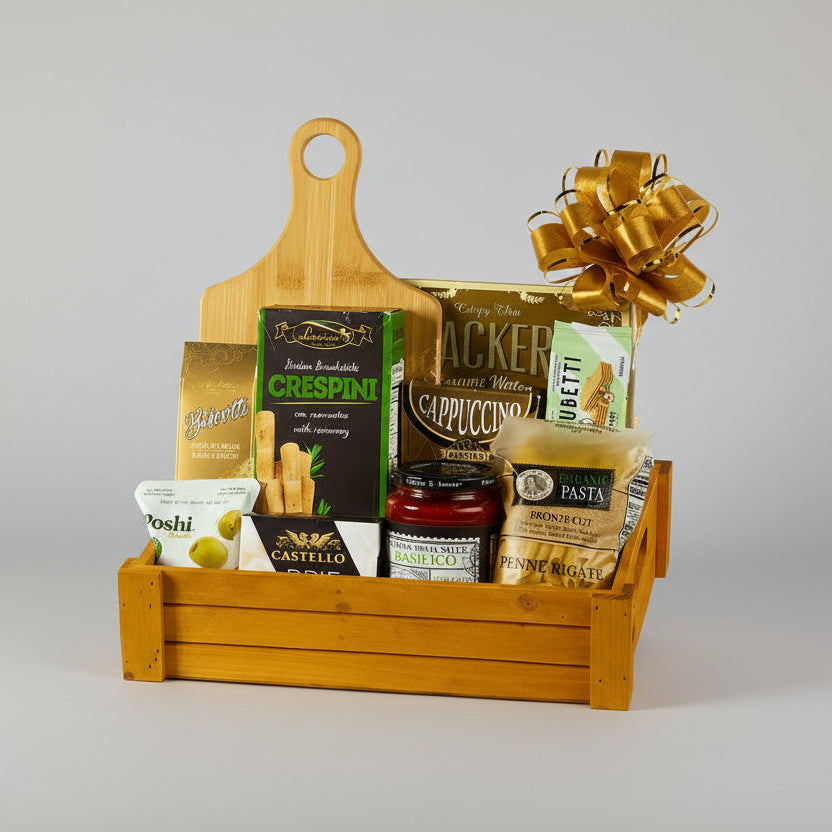 Gift basket with wooden cutting board, pasta, and other food items on a white background